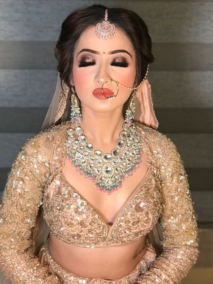 A close-up of a stunning party makeup look. We focused on dramatic smokey eyes with a sharp wing, a perfectly contoured base, and a glossy nude lip. The heavy diamond necklace adds to the overall glamorous feel.