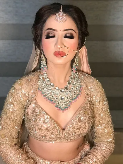A close-up of a stunning party makeup look. We focused on dramatic smokey eyes with a sharp wing, a perfectly contoured base, and a glossy nude lip. The heavy diamond necklace adds to the overall glamorous feel.