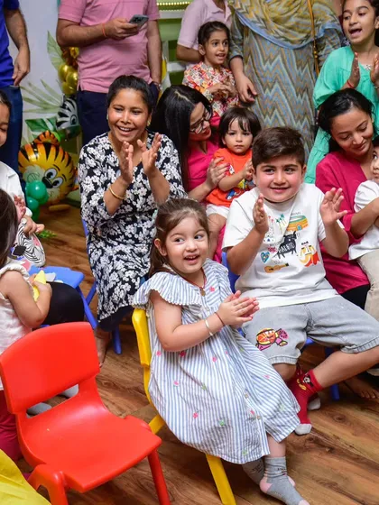 An audience of happy, clapping kids and parents enjoying the entertainment.