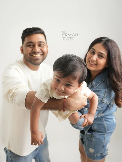 A playful lift towards the camera shows off this little one's charming personality. This happy family portrait is a perfect example of how we can capture your family's energy in the studio.