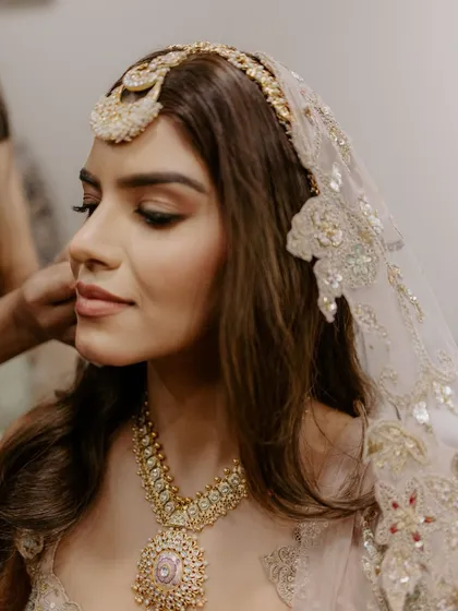 A close-up of the soft and ethereal bridal look. The makeup is subtle yet defining, perfect for her delicate pastel outfit.