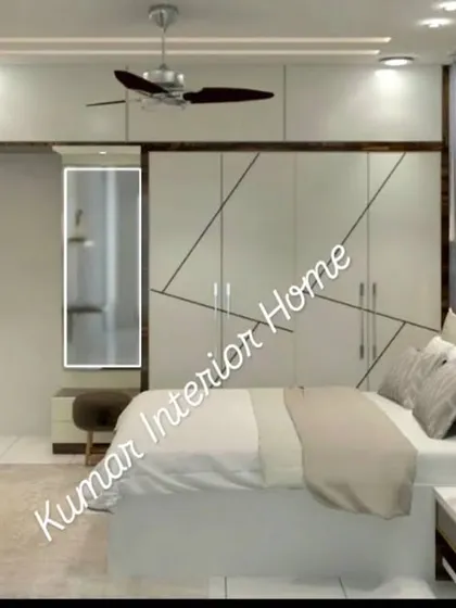 This angle shows the bed and the full-height wardrobe with an integrated dressing mirror. The design is clean, white, and highly functional.