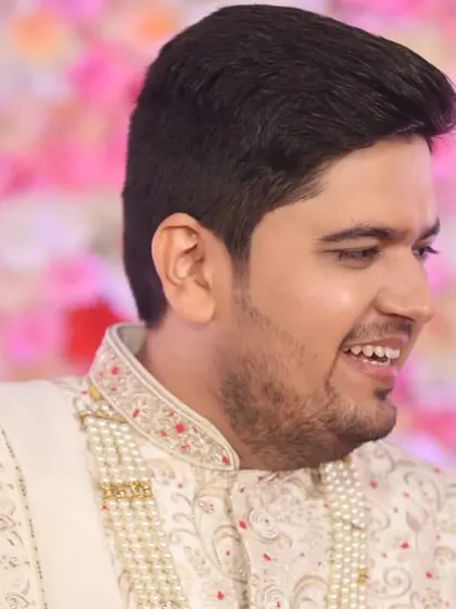 A candid shot capturing the groom's smile. The makeup looks natural and doesn't crease, even with expressive moments like this.