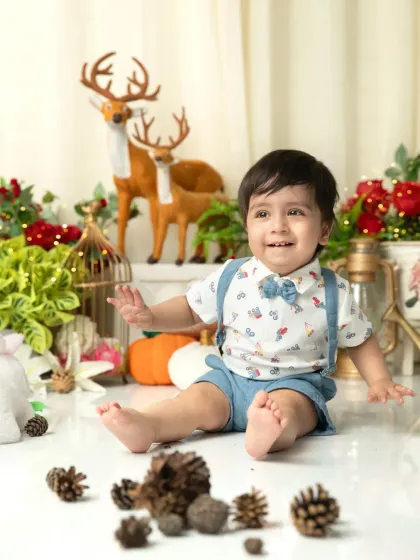 A happy smile from our little model. The combination of his cute outfit and the festive background makes for a perfect holiday birthday card photo.