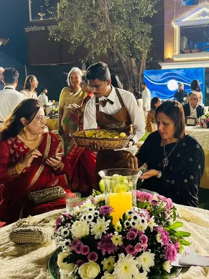 Our service goes beyond the bar. Here, a team member serves appetizers to guests at their table, ensuring a complete and attentive hospitality experience throughout the event.