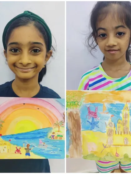 Two girls show their different interpretations of a beach scene. One painted a vibrant sunset over the ocean, while the other focused on a magnificent sandcastle, demonstrating individual creativity.