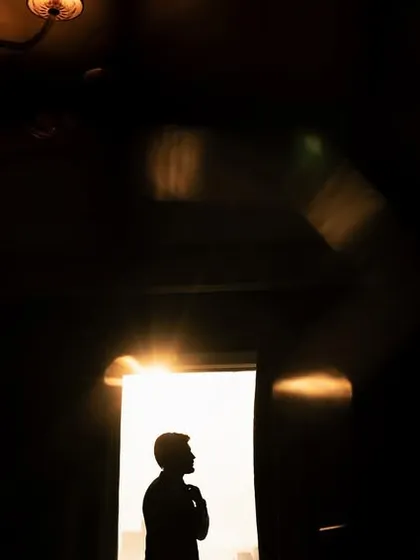 I am always chasing the light. This silhouette of a groom, framed by the doorway just before his reception, uses shadow and a sliver of golden hour sun to create a feeling of anticipation and quiet confidence.
