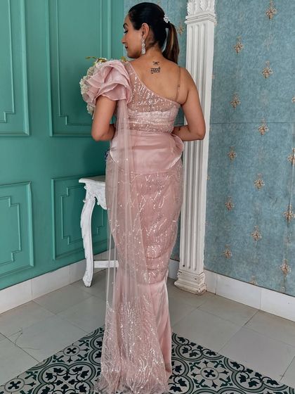 The back view of this elegant pink draped saree, showing the one-shoulder design and sparkling fabric.