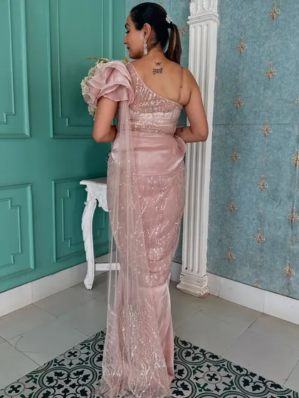 The back view of this elegant pink draped saree, showing the one-shoulder design and sparkling fabric.