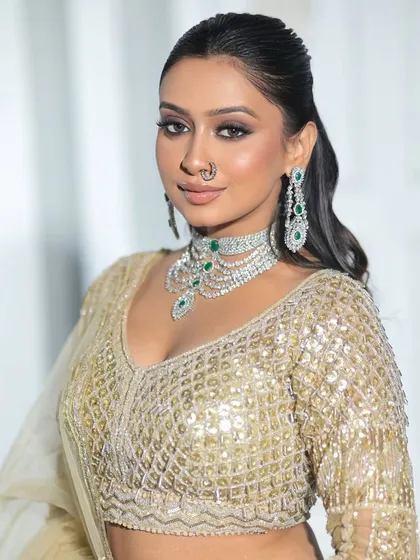 A close-up portrait in our all-gold sequin lehenga. The V-neck blouse is flattering and pairs perfectly with a statement necklace.