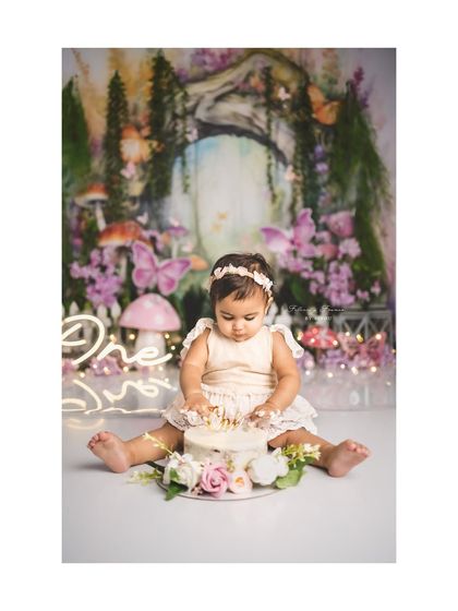 A fairy's first cake smash! This enchanted forest theme, complete with mushrooms and butterflies, creates a magical setting for a first birthday.