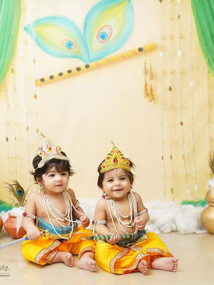 Double the trouble, double the love! These adorable twin boys are dressed as little Krishnas for their milestone photoshoot, creating a picture of divine cuteness.