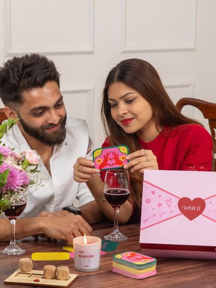 A happy couple enjoying a glass of wine with our "Mischief Date Night" box. It’s designed to spark connection and laughter, making for a perfect evening in.