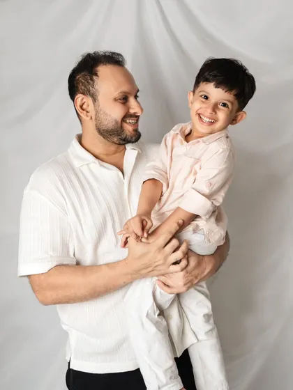 A classic father and son portrait. The simple background and their bright smiles make this a timeless and heartwarming photograph.