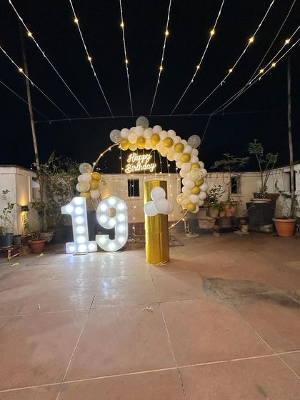 A wider view of the rooftop 19th birthday party, showing the full extent of the fairy light canopy and decoration.