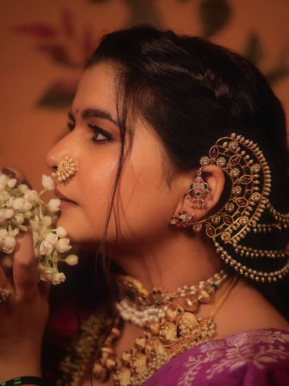 A profile shot highlighting the intricate ear cuff (kaan vel) and the classic Maharashtrian nath. These details are essential for an authentic and complete traditional look.