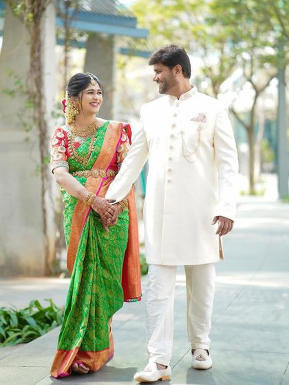 A full-length shot of a couple in coordinated traditional outfits. This image showcases their chemistry and the elegance of their attire in a natural, outdoor setting.