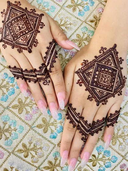 A clear shot of the geometric diamond design on the back of the hands. This style is perfect for someone who wants a non-traditional, chic mehndi look.