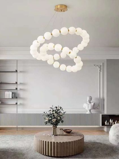 A flowing, cloud-like chandelier made of frosted white glass globes. This artistic piece is perfect for creating a soft, dreamy ambiance in a living room.