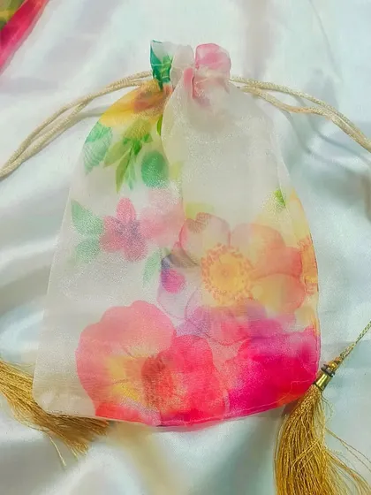 This floral printed organza potli bag is an elegant and stylish choice for gift packaging. The delicate design and tassel details make it a beautiful keepsake.