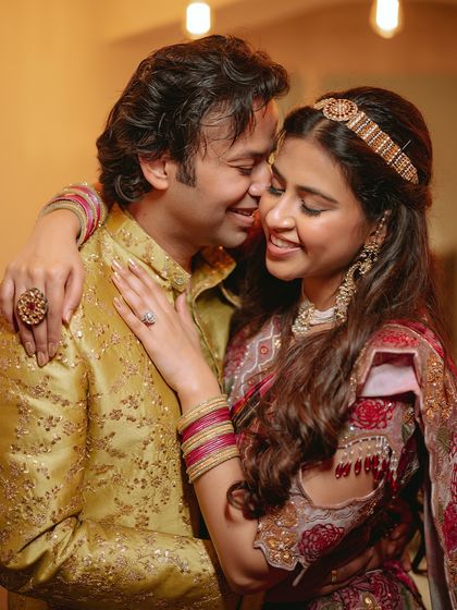 A warm, affectionate embrace between the couple, their smiles telling a story of love and happiness.