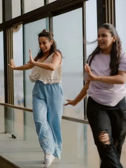 Two participants completely in the moment during a dance workshop by the sea. Our sessions are designed to help you forget everything else and just enjoy the movement and music.