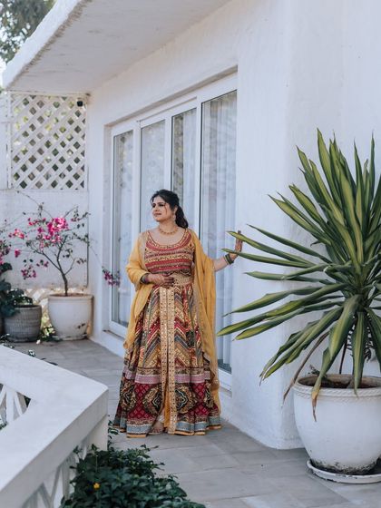 The bride looking radiant against a white bougainvillea-laden wall. I scout for the best photo spots at the venue to ensure the couple gets stunning portraits.