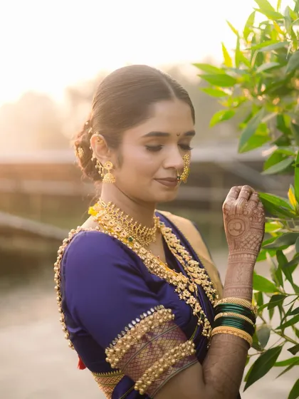A stunning portrait of the bride in her Nauvari saree, bathed in the golden hour light.
