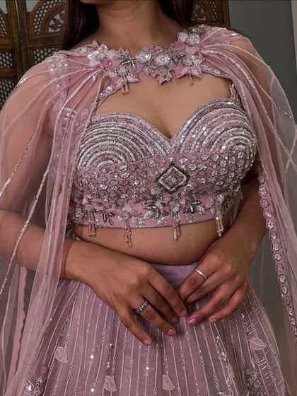 A detailed close-up of the heavily embellished blouse and the unique cape neckline. The craftsmanship on this pre-loved piece is exceptional.