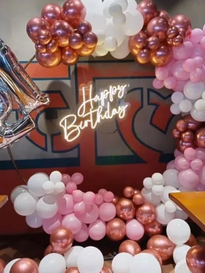 Milestone birthdays deserve a special touch. For this 21st birthday, we created a stylish balloon arrangement with rose gold chrome, pink, and white balloons, a "Happy Birthday" neon sign, and large "21" foil numbers.