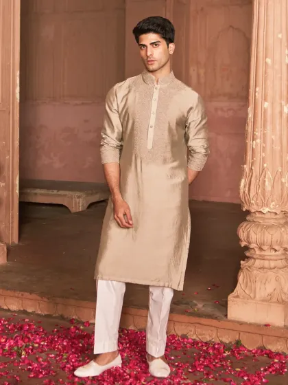 This neutral toned kurta set is a study in quiet confidence. The clean lines and subtle tone on tone embroidery on the placket make it a refined choice for any festive gathering.