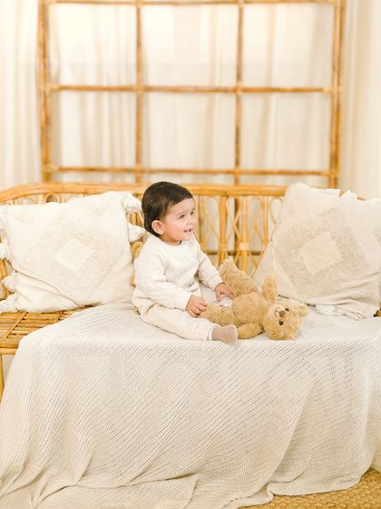 A candid moment from a sitter session. The baby looks off to the side, creating a natural and thoughtful portrait that captures his curiosity.