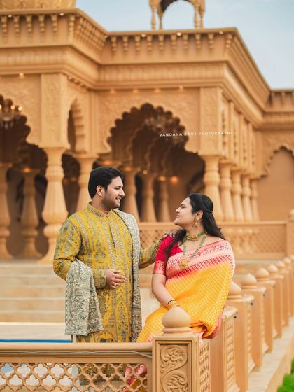 Dressed in elegant ethnic wear, this couple's pre-wedding shoot at a heritage location combines tradition with grandeur. The intricate architecture provides a timeless backdrop for their portraits.