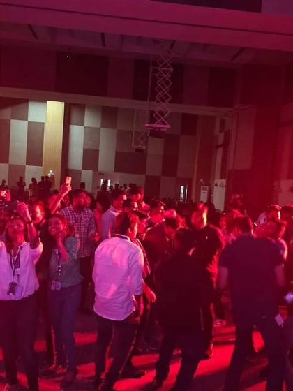 The crowd at ITC Infotech enjoying the music and dancing under the red lights.