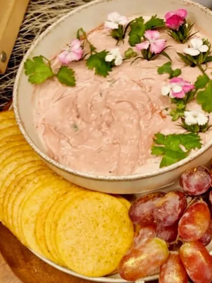 Our Sol Kadi inspired handcrafted cheese dip. This unique creation, garnished with edible flowers, is a beautiful and flavorful centerpiece for a summer brunch.