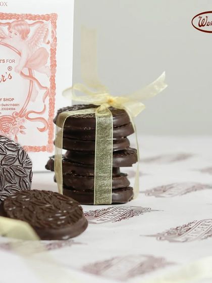A stack of our chocolate-dipped biscuits, tied with a ribbon. These simple, elegant cookies are perfect with a cup of tea or coffee.