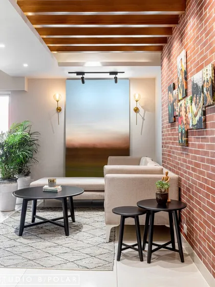 This living area features a more subdued palette with an exposed brick wall for texture. A gallery of family photos makes the space deeply personal and turns a simple wall into a collection of memories.