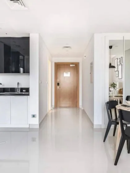 A render of a bright and clean entryway and kitchenette for a studio apartment, demonstrating a smart and efficient use of space.