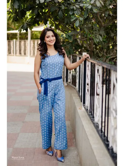 A full-length fashion portrait. This shot showcases the entire outfit, a stylish blue printed jumpsuit, giving a complete look for a brand collaboration or portfolio.