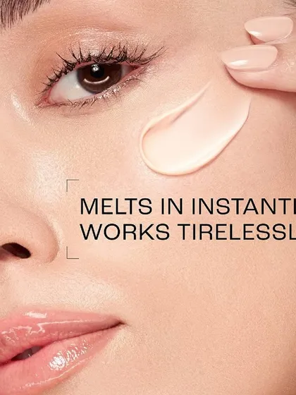 A macro beauty shot for a Lakmé skincare advertisement, demonstrating the product's texture. The image shows a creamy formula being applied to the model's cheek, with text overlay explaining how it "melts in instantly," focusing on the sensory experience of the product.