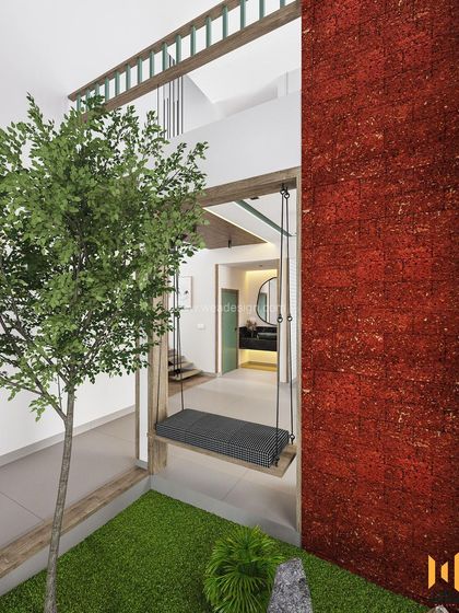 A close-up of the indoor courtyard and swing, showing the laterite stone wall and the sense of tranquility it brings to the home.