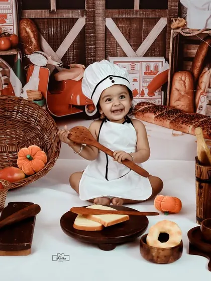A happy little chef playing with a big wooden spoon. Our chef theme is full of fun props that encourage play and result in wonderfully natural and expressive photos.