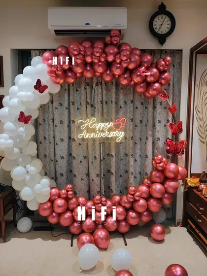 An intimate and elegant 50th anniversary celebration at home. We used a semi-arch of metallic red and white balloons with butterfly accents and a custom neon sign.