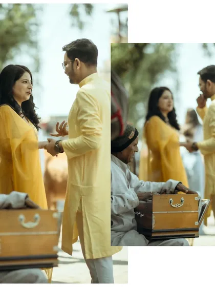 A couple shares a moment during their pre-wedding shoot, with a local musician playing a harmonium in the foreground, adding a touch of authentic culture to their story.