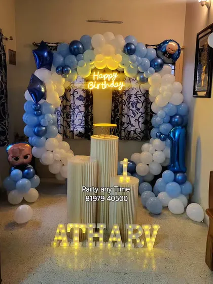 This Boss Baby theme for a first birthday features a blue and white balloon arch, character foil balloons, and light-up letters for the name.