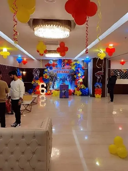 A wide view of a Transformers themed party in a banquet hall. This shows how I can decorate a large space with ceiling balloons and a main stage setup to create an immersive experience.