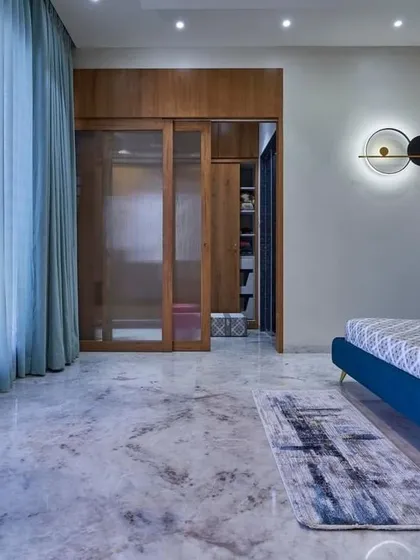 Another view of this spacious bedroom, showing the walk-in closet concealed behind sliding glass and wood doors. The design maintains a clean, uncluttered look while providing ample storage.