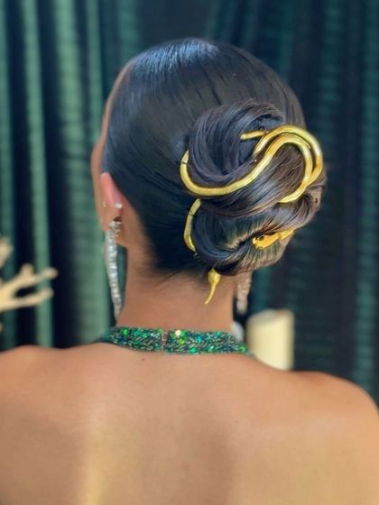 The final result: a clean, polished bun transformed into a work of art with a unique, serpentine hairpiece.