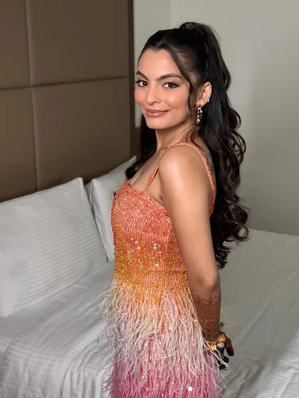 A fun, over-the-shoulder pose. The high ponytail and glowing skin give this look a playful yet polished vibe, perfect for a cocktail party.