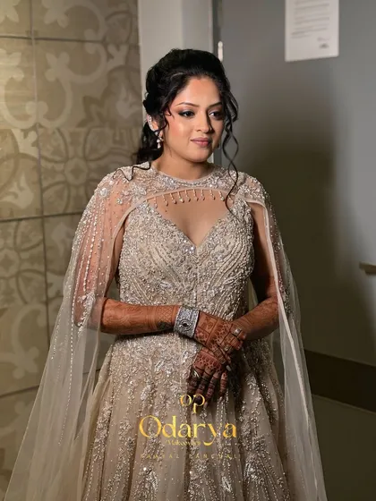 A full-length view of the bride in her breathtaking Sangeet gown with a sheer cape. The makeup and hair are styled to complement the modern, ethereal vibe of her outfit.